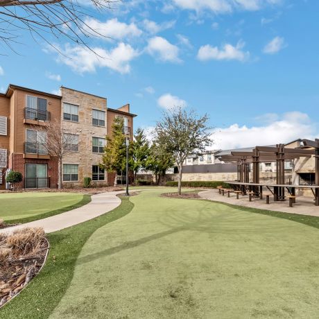 Gateway Cedars apartment exterior with outdoor fireplace and groomed green lawn