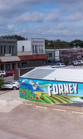 Downtown Forney, TX landscape featuring large mural on side of building with local decor