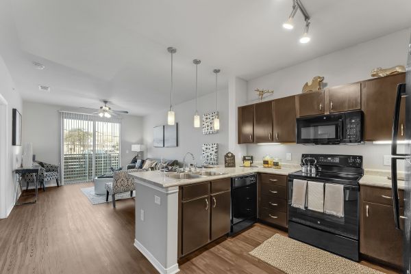 Gateway Cedars apartment designer kitchen with granite countertops and pendant lighting in open floor plan unit