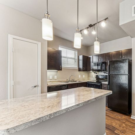 Gateway Cedars apartment designer kitchen with granite countertops and pendant lighting