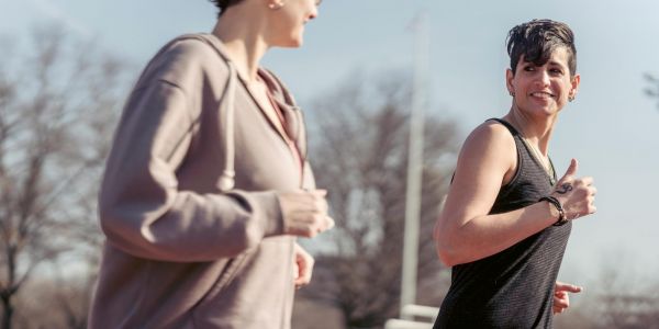 Two women running in a park oudoors on a sunny day